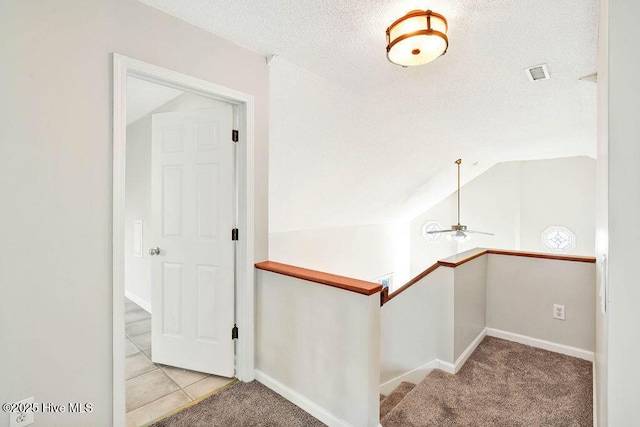 staircase featuring carpet flooring, ceiling fan, a textured ceiling, and vaulted ceiling