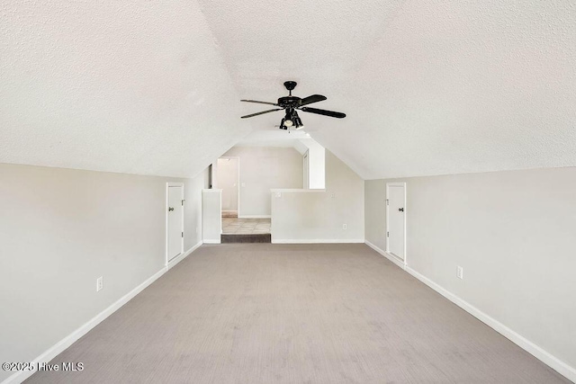 bonus room featuring a textured ceiling, vaulted ceiling, and ceiling fan