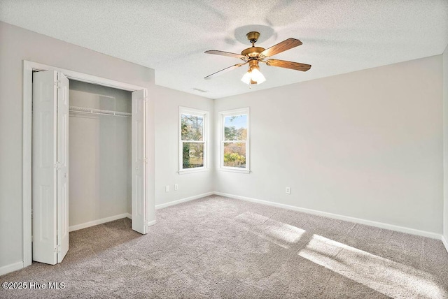 unfurnished bedroom featuring carpet flooring, ceiling fan, a textured ceiling, and a closet