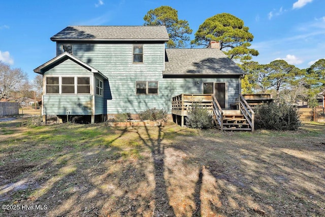 back of property with a deck and a sunroom