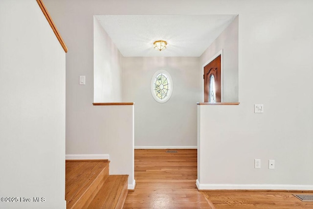 corridor with hardwood / wood-style floors