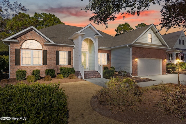 4379 Gauntlet Dr, Southport, NC 28461 - view of front facade featuring brick siding, a garage, driveway, and a shingled roof