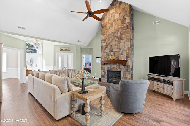 4379 Gauntlet Dr, Southport, NC 28461 - living area featuring high vaulted ceiling, wood finished floors, a ceiling fan, a fireplace, and a chandelier