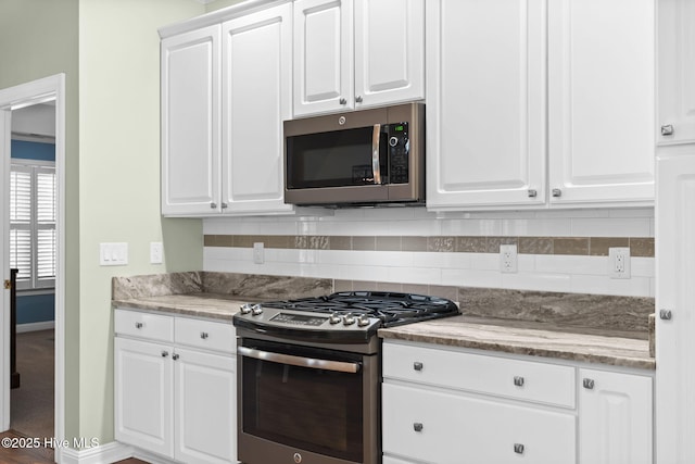 4379 Gauntlet Dr, Southport, NC 28461 - kitchen with stainless steel appliances, tasteful backsplash, baseboards, and white cabinetry