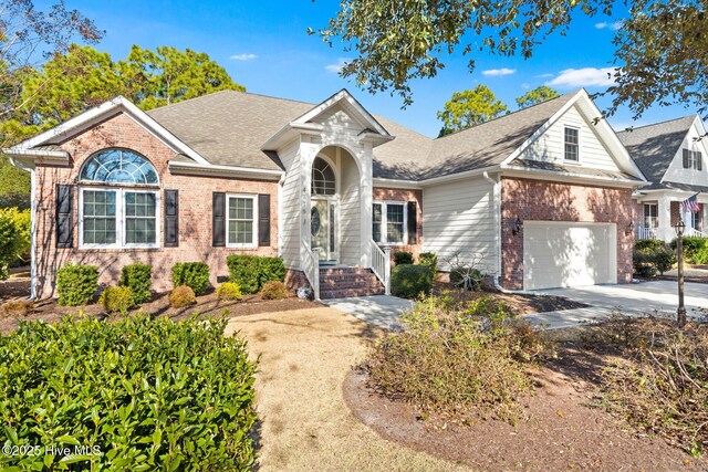 4379 Gauntlet Dr, Southport, NC 28461 - traditional home with brick siding, driveway, roof with shingles, and an attached garage