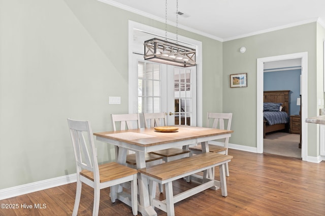 4379 Gauntlet Dr, Southport, NC 28461 - dining space featuring a chandelier, crown molding, baseboards, and wood finished floors
