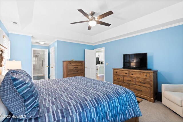 carpeted bedroom featuring a tray ceiling, ceiling fan, and ornamental molding