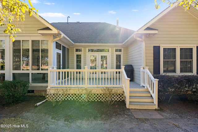 4379 Gauntlet Dr, Southport, NC 28461 - rear view of property featuring roof with shingles, a deck, and a sunroom