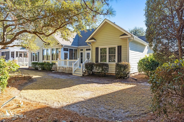 4379 Gauntlet Dr, Southport, NC 28461 - back of house with a sunroom and a shingled roof