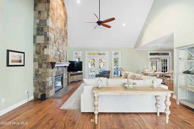 4379 Gauntlet Dr, Southport, NC 28461 - living room featuring high vaulted ceiling, a ceiling fan, french doors, a fireplace, and wood finished floors