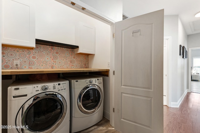 laundry room featuring separate washer and dryer and light hardwood / wood-style flooring