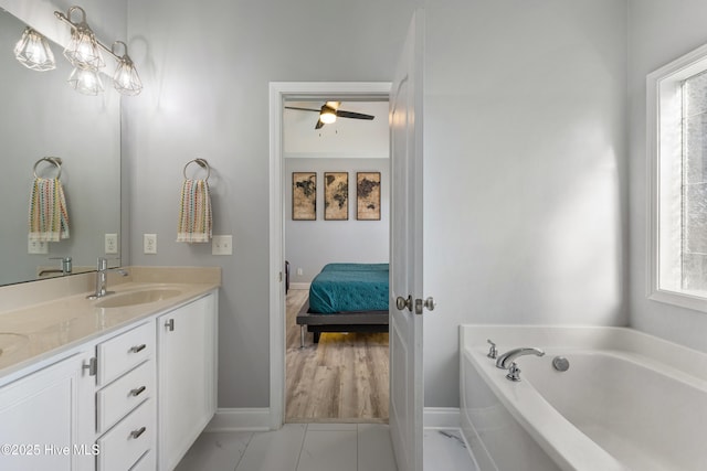 bathroom with vanity, a bathing tub, a wealth of natural light, and ceiling fan