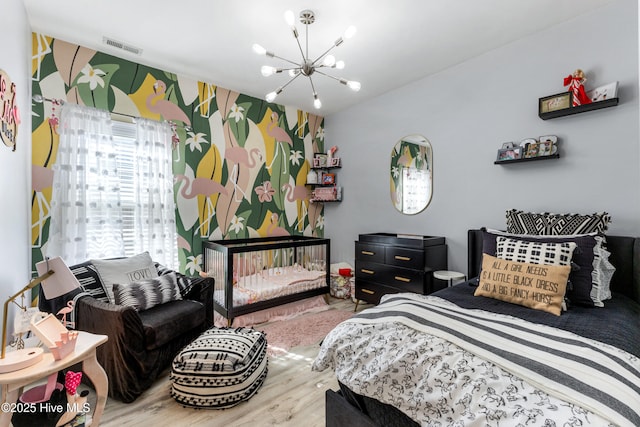 bedroom with hardwood / wood-style floors and a chandelier