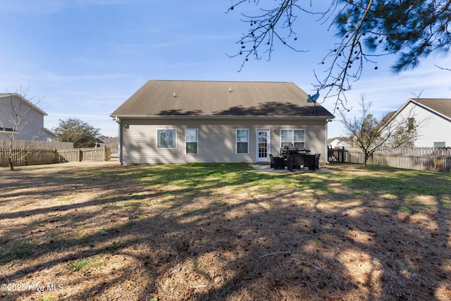 back of house with a lawn and a patio