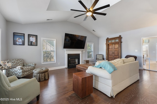 living room featuring ceiling fan, dark hardwood / wood-style floors, and vaulted ceiling