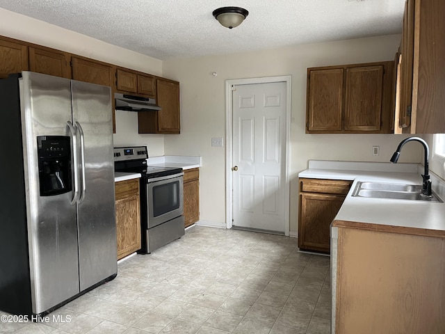 kitchen featuring appliances with stainless steel finishes, sink, and a textured ceiling