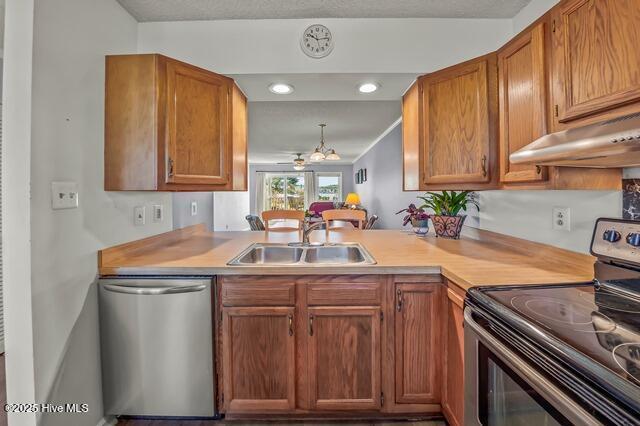 kitchen with sink, kitchen peninsula, stainless steel appliances, and a chandelier