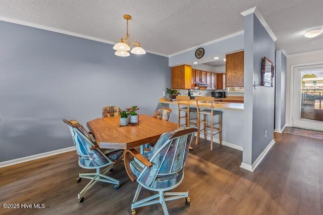 dining space featuring a textured ceiling, a notable chandelier, dark hardwood / wood-style floors, and crown molding