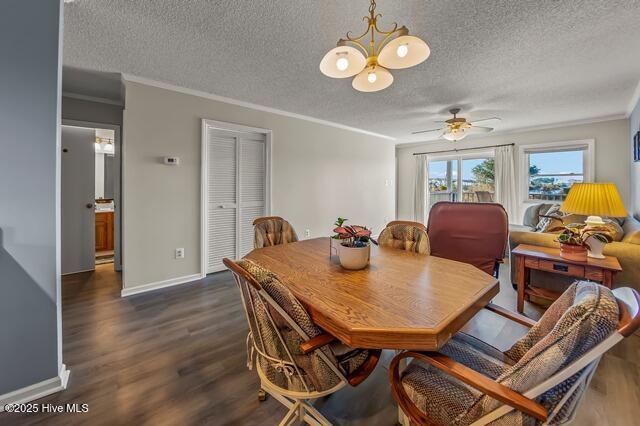 dining area with a textured ceiling, ceiling fan with notable chandelier, dark hardwood / wood-style flooring, and crown molding