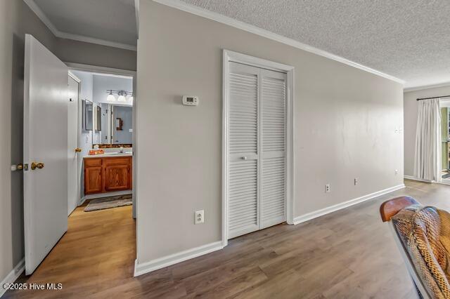 interior space with hardwood / wood-style floors, a textured ceiling, and ornamental molding