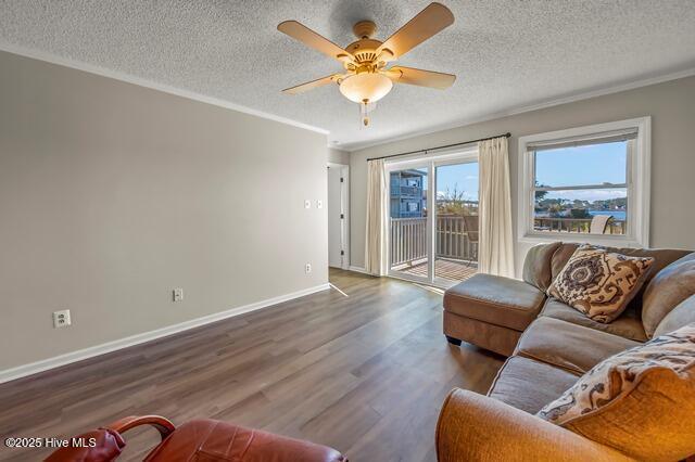 living room featuring ceiling fan, hardwood / wood-style floors, a textured ceiling, and ornamental molding