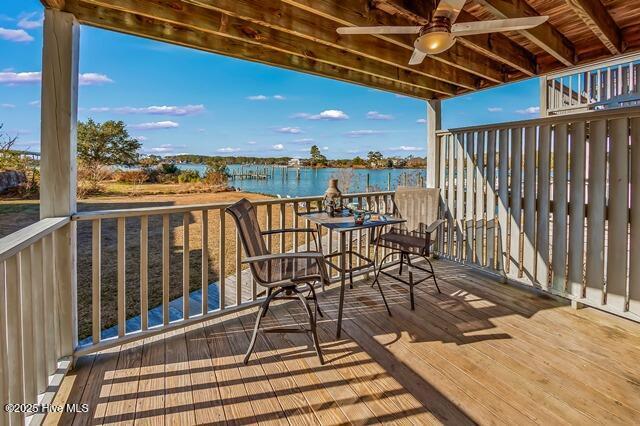 wooden deck featuring ceiling fan and a water view