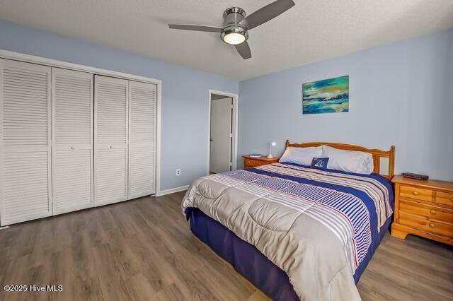 bedroom featuring a textured ceiling, a closet, ceiling fan, and dark hardwood / wood-style floors