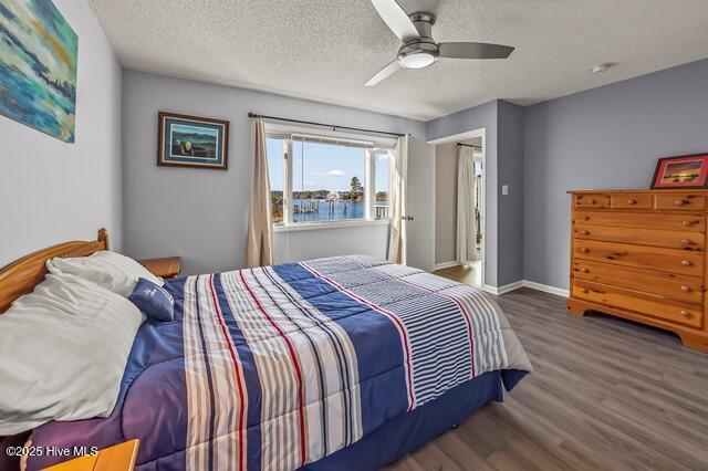 bedroom featuring ceiling fan, dark hardwood / wood-style floors, and a textured ceiling