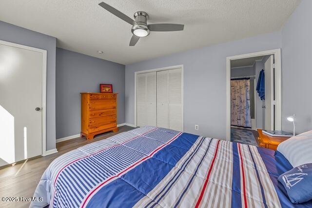 bedroom featuring wood-type flooring, a textured ceiling, a closet, and ceiling fan