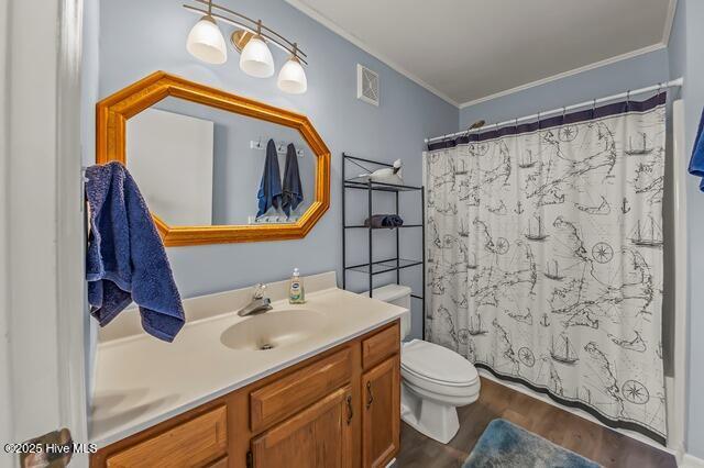 bathroom with hardwood / wood-style floors, vanity, toilet, and ornamental molding