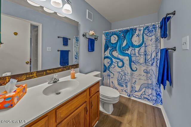 bathroom with a shower with shower curtain, vanity, wood-type flooring, and toilet