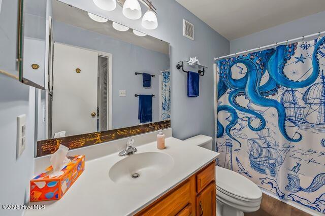 bathroom with vanity, a shower with shower curtain, and toilet