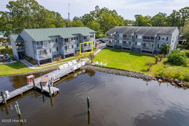 rear view of house with a water view and a yard