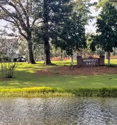 view of home's community featuring a lawn and a water view