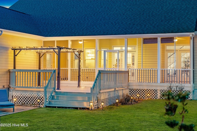 back of property featuring roof with shingles, a yard, and a pergola