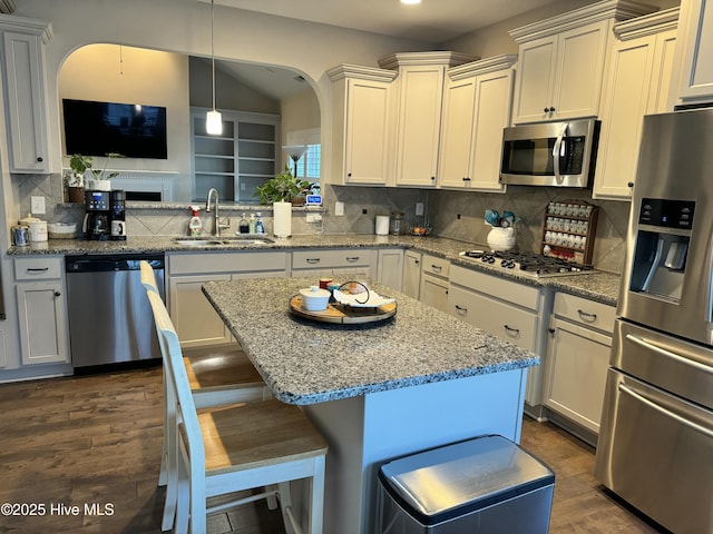 kitchen featuring tasteful backsplash, pendant lighting, sink, a kitchen breakfast bar, and stainless steel appliances