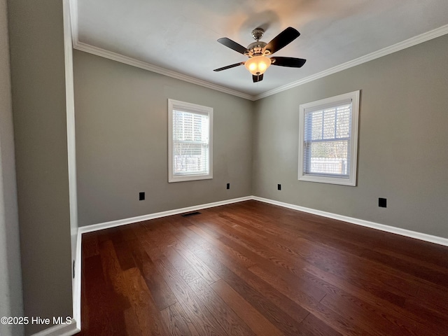 empty room with a wealth of natural light, dark hardwood / wood-style flooring, and ornamental molding