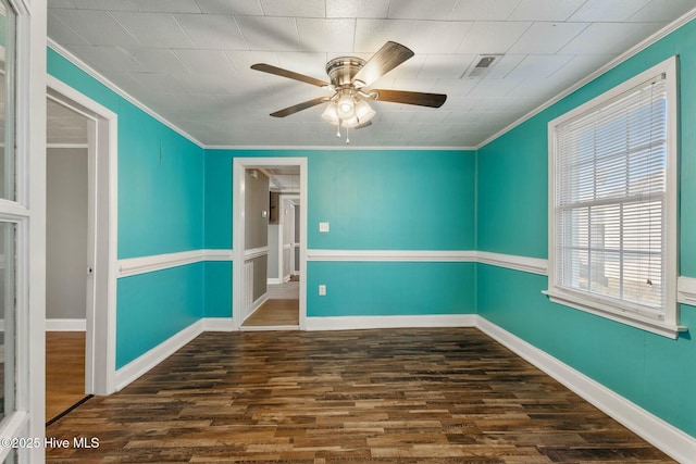 empty room with baseboards, visible vents, ceiling fan, ornamental molding, and wood finished floors