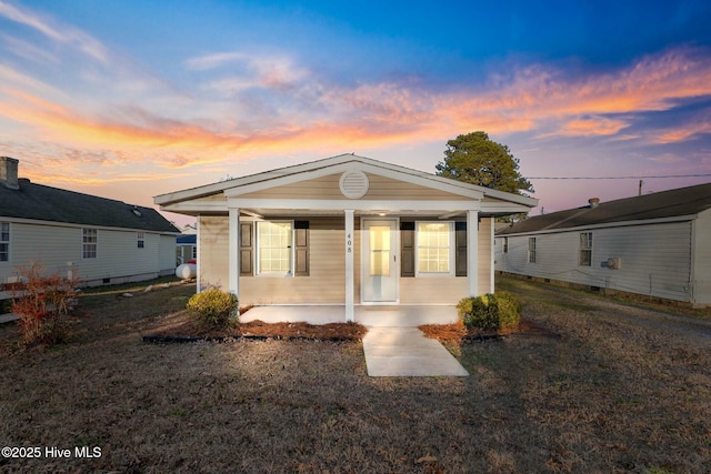 view of front of property featuring covered porch and a lawn