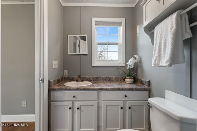 half bath featuring toilet, baseboards, and vanity