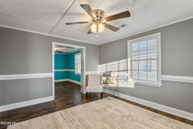 unfurnished room featuring visible vents, crown molding, baseboards, and wood finished floors