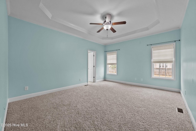 unfurnished room with carpet floors, a tray ceiling, ceiling fan, and ornamental molding