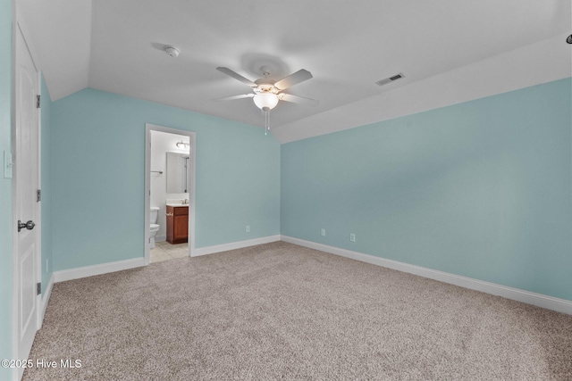 unfurnished bedroom featuring ceiling fan, ensuite bathroom, lofted ceiling, and light carpet