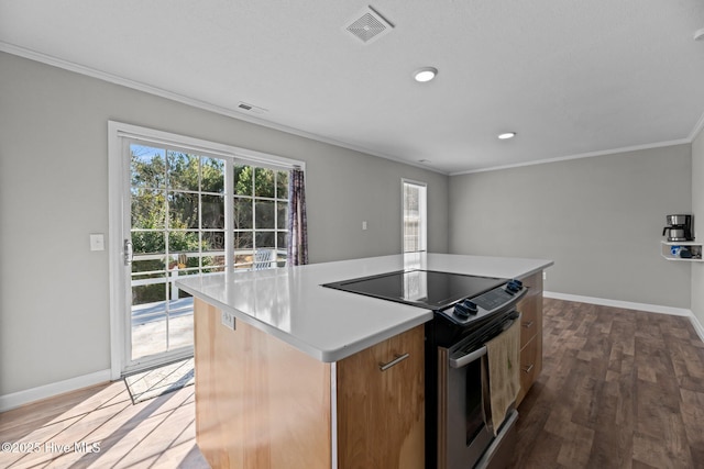 kitchen with stainless steel electric range oven, a center island, wood-type flooring, and ornamental molding