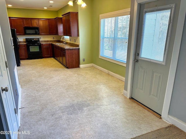 kitchen featuring sink, light tile patterned floors, and black appliances