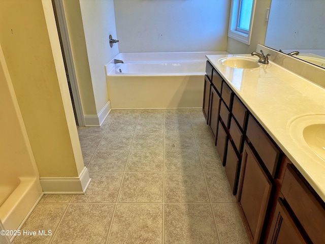 bathroom featuring tile patterned flooring, a bath, and vanity