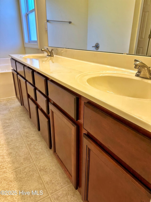 bathroom with tile patterned floors, vanity, and a bath