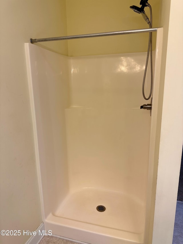 bathroom with tile patterned flooring and a shower