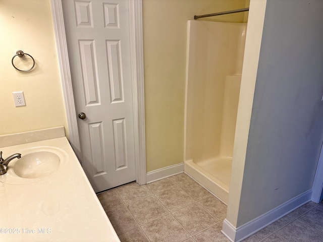 bathroom featuring tile patterned flooring, vanity, and walk in shower