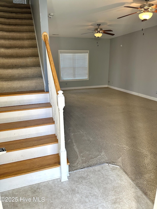 stairway featuring ceiling fan